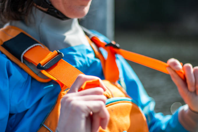 The length of the shoulder straps of the life jacket is adjusted by pulling the straps.