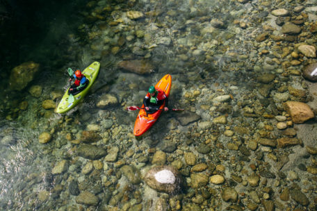 Two people in a kayak paddling on crystal clear water at Private Course.